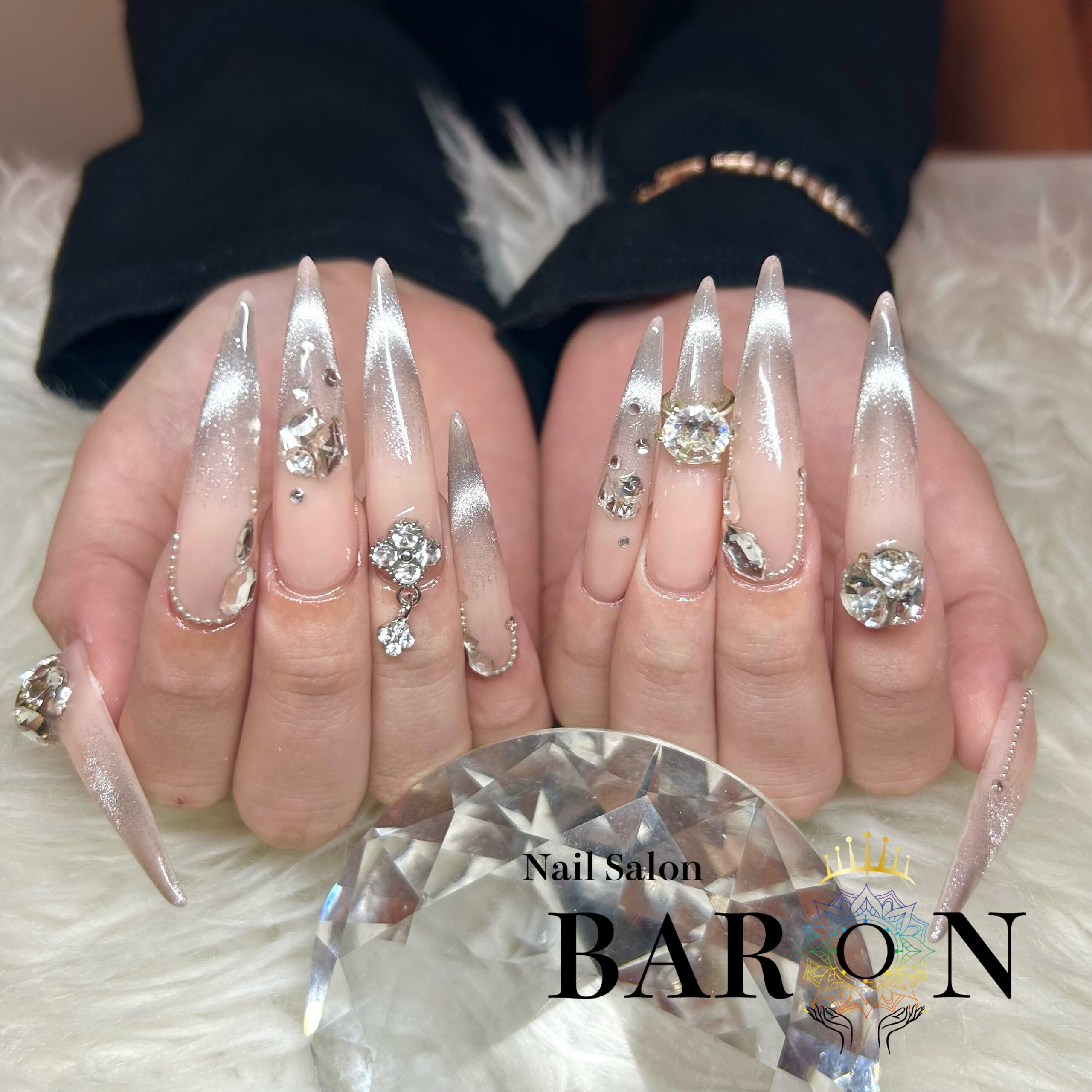 BARON Shinjuku long pointed nails with a nude base, silver-toned magnetic French tips and large rhinestone decorations