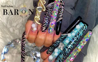 BARON新宿店が3枚MAXアートとして紹介したロングスカルプ。黒とラメのゼブラ柄、大粒ビジュー、金色の装飾を配置