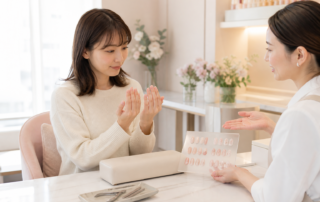 自爪の状態を個室サロンでネイリストに相談する女性