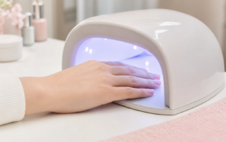 ジェルネイルをLEDライトで硬化している女性の手元